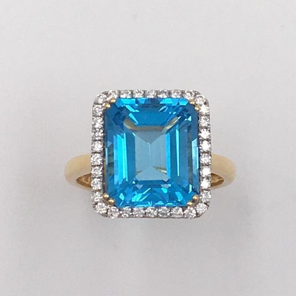 BAGUE rectangulaire en or jaune (750 millièmes) serti d'une topaze bleue taillée à degrés, entourée de diamants taille brillan