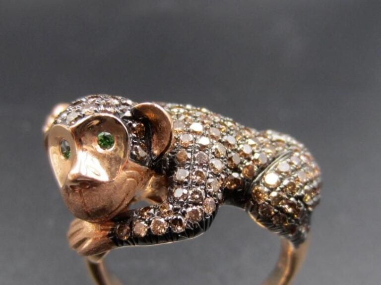 BAGUE « singe » en or rose et or noirci (750 millièmes) ciselé, les yeux ornés de grenats tsavorite et pavé de diamants bruns             Doigt : 53        Poids brut : 8,7 g