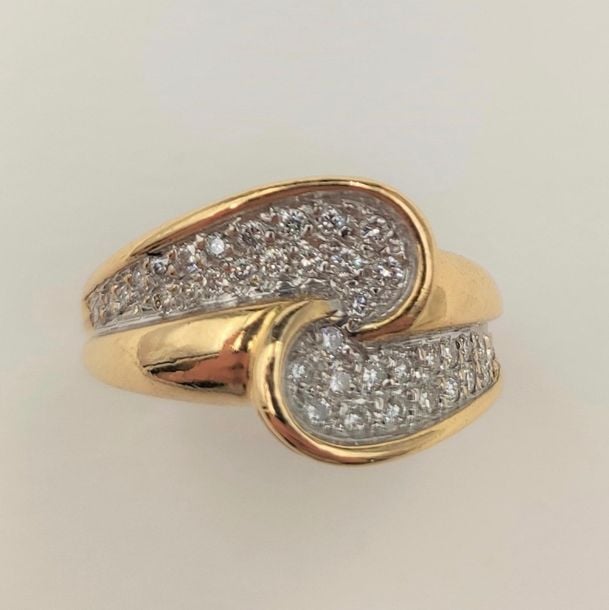 •BAGUE «sinueuse» en or jaune (750‰) partiellement pavé de diamants taille brillan