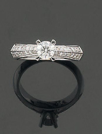 BAGUE solitaire en or gris serti d'un diamant épaulé d'un double alignement de diamants taille brillan