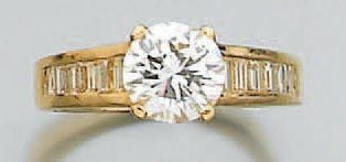 BAGUE solitaire en or jaune sertie d'un diamant de taille brillant épaulé d'un alignement de diamants baguettes de chaque côt
