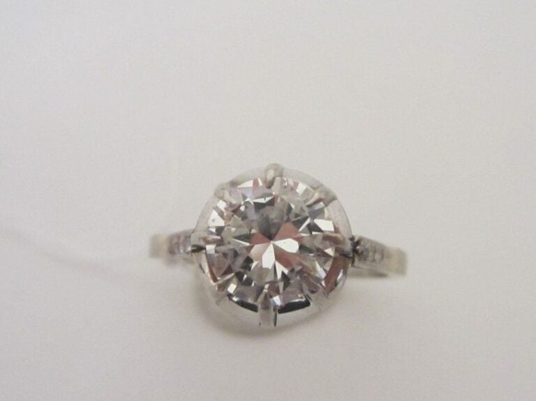 BAGUE solitaire en platine (900 millièmes) serti d'un diamant demi-taille épaulé de diamants 8/