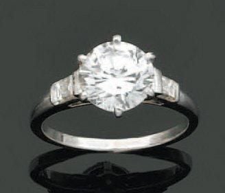BAGUE solitaire en platine serti d'un diamant taille brillant épaulé de deux diamants baguette