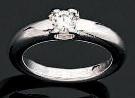 BAGUE solitaire, modèle «Louis Cartier», en or gris ajouré serti d'un diamant taille brillan