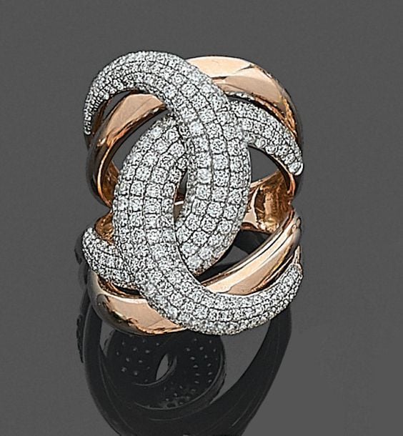 •BAGUE «stylisée» en or rose (750‰) ajouré à motif de double «C», partiellement pavé de diamants taille brillan