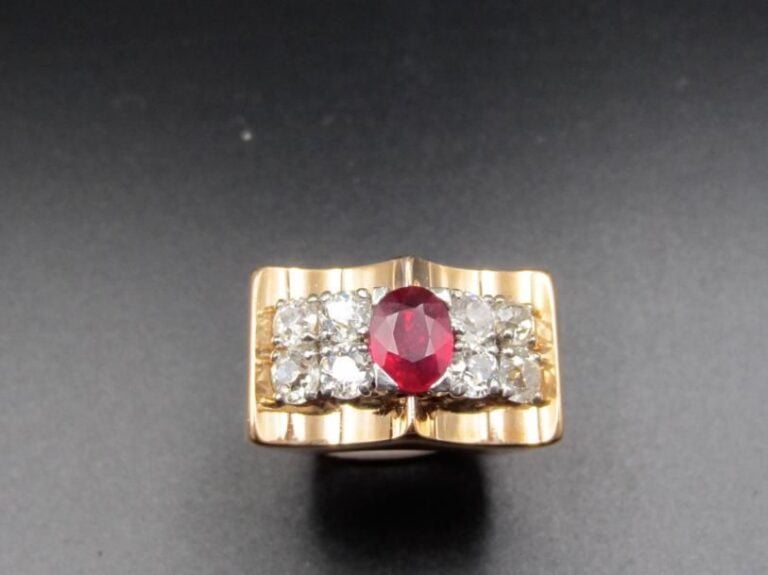 BAGUE tank en platine (min        800 millièmes) or jaune (750 millièmes) serti d’un rubis de forme ovale épaulé de huit diamants taille ancienne              Doigt : 50 (Trace de mise à taille)        Poids brut : 17,2 g
