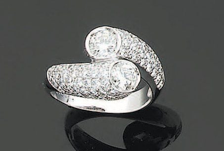 BAGUE « toi et moi » en or gris serti de deux diamants de taille brillant épaulés de pavages de diamant