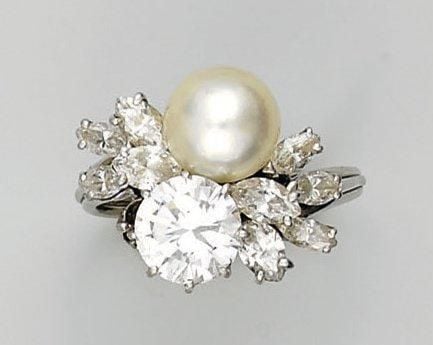 BAGUE «toi et moi» en platine serti d'un diamant taille brillant et d'une perle de culture blanche épaulés de diamants navette (dont un manquant