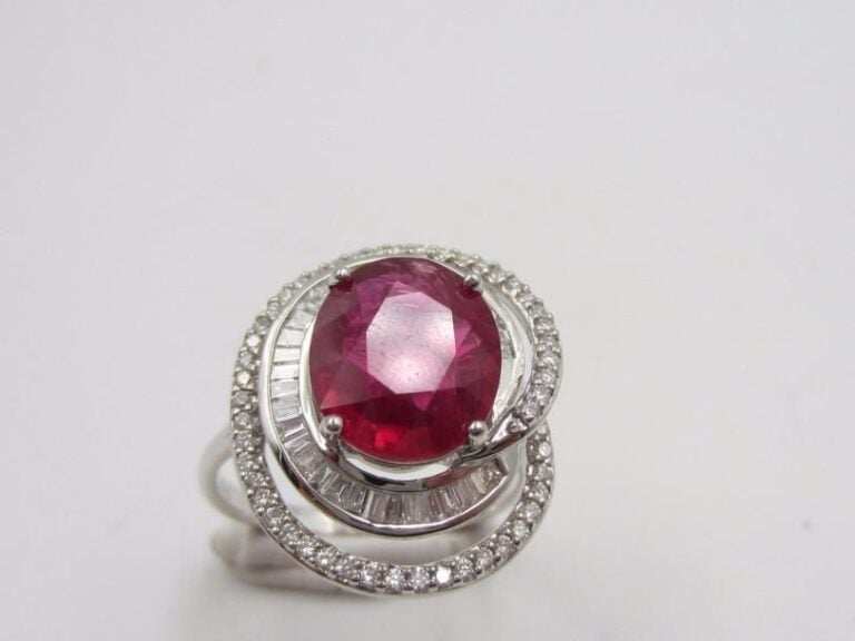 BAGUE « tourbillon » en or gris (750 millièmes) ajouré, serti d’un rubis pesant 3,42 carats, entouré de diamants baguettes et taille brillan