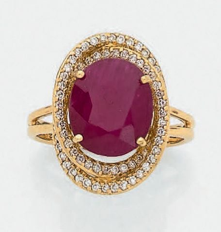 BAGUE «tourbillon» en or jaune (750 millièmes) ajouré, serti d'un rubis de forme ovale, pesant 4,98 carats, entouré de diamants taille brillan