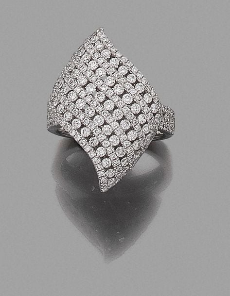 •BAGUE «volute» en or gris (750 ‰) ajouré, pavé d'alignements de diamants taille brillan