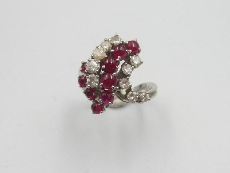 BAGUE «volute» en or gris (750 millièmes) serti de lignes sinueuses de diamants et rubis cabochon
