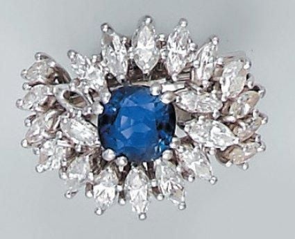 BAGUE "volutes" en platine ajouré serti d'un saphir de forme coussin et de diamants navette