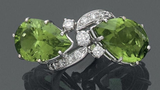 BAGUE «vous et moi» en or gris (750 millièmes) orné de deux péridots de forme poire, soulignés de diamants taille brillant dont trois plus important