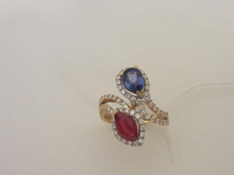 BAGUE «vous et moi» en or rose et or gris (750 millièmes) ajouré et serti d'un saphir de forme poire et un rubis de forme navette soulignés de diamants taille brillan
