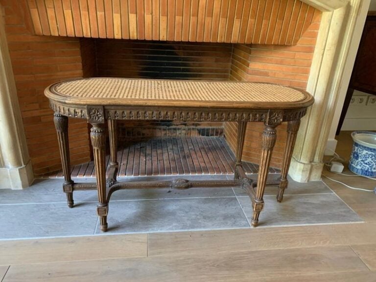 Banquette ovale cannée en bois naturel reposant sur six pieds fuselé
