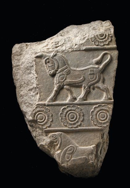 BAS-RELIEF AUX ANIMAUX Relief représentant sur deux registres séparés par un bandeau de trois rosettes un taureau et un lion passan