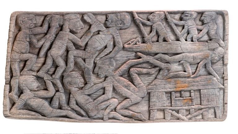 Bas-relief en bois sculpté représentant l'attaque d'un villag
