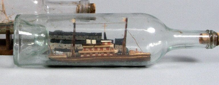 BATEAU BOUTEILLE LANNION avec bateau mixte dans un diorama figurant le port de Lannion avec inscrit sur les façades des maisons : Café de Lannion, Hôtel Continental, Epicerie, Bon Cidr