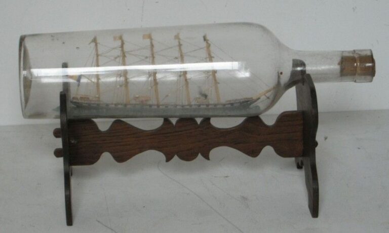Bateau en bouteille représentant un cinq-mâts -barque sur une mer en mastic Socle de présentation en bois sculpté