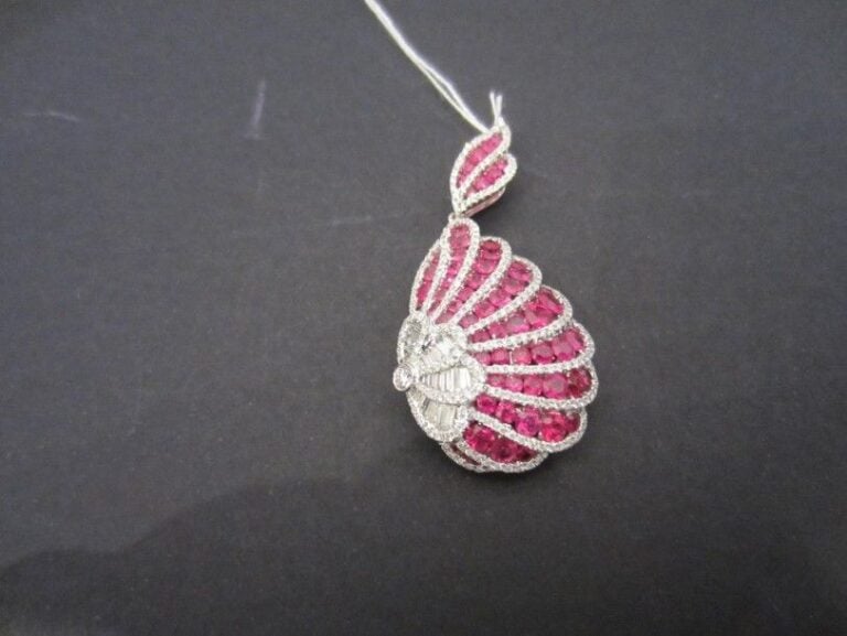 Beau PENDENTIF «volutes» en or gris (750 millièmes) serti de rubis ronds alternés de lignes de diamants taille brillant e baguettes