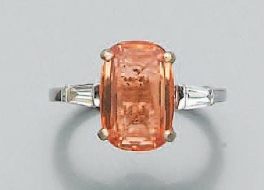Belle BAGUE en or gris serti d'un saphir orange de forme coussin épaulé de deux diamants taeper