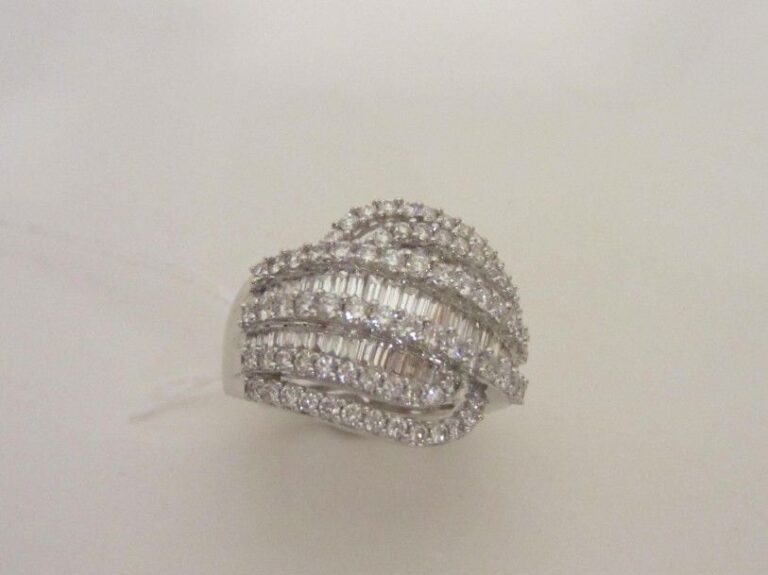Belle BAGUE «volute» en or gris (750 millièmes) ajouré serti d'alignements de diamants baguettes alternés de diamants taille brillan