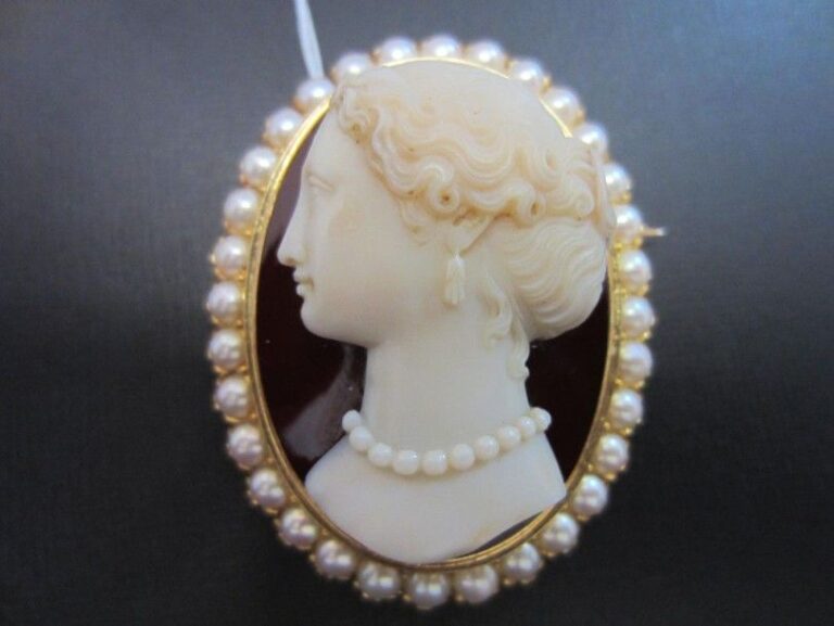 Belle BROCHE ovale en or jaune et or rose (750 millièmes) serti d'un important camée de cornaline «profil de femme» (petit fêle) entouré de demi-perle