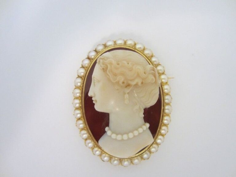 Belle BROCHE ovale en or jaune et or rose (750 millièmes) serti d?un important camée de cornaline «profil de femme» (petit fêle) entouré de demi-perle