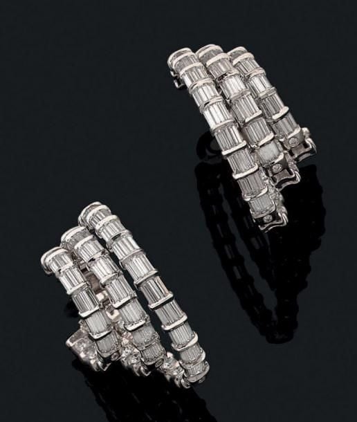 Belle PAIRE DE BOUCLES D'OREILLES en or gris (750 millièmes) composé de trois rangs elliptiques sertis de diamants baguette