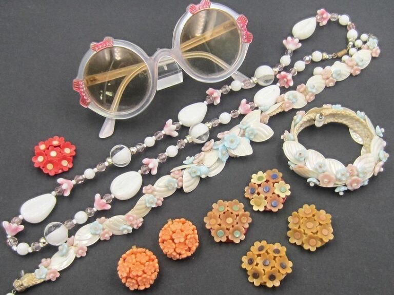 Bijoux de plage, comprenant: collier et bracelet coquillages (années 1950), collier en verre Murano, 5 broches fleurs en bakélite, paire de clips d'oreille fleurs couleur corail, paire de lunette