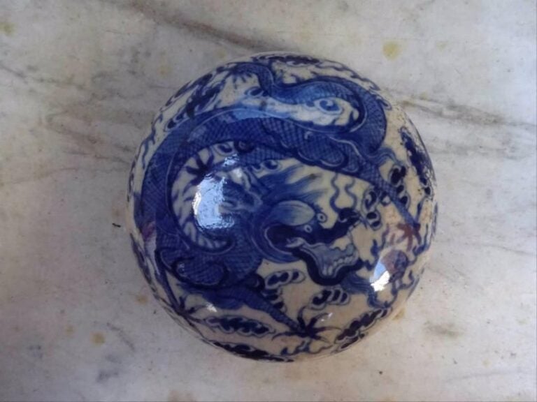 BOITE A ENCRE POUR SCEAU A DECOR DE DRAGON Chine, Epoque XXe siècle, Dans le goût des productions de la période Kangxi De forme lenticulaire, en porcelaine à décor exécuté en bleu cobalt sous couverte de dragon à cinq griffes volant parmi des volutes nuageuses à la poursuite de la perle enflammé