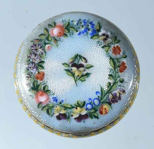 Boîte à pilules ronde en argent guilloché émaillé bleu clair à guirlandes de fleurettes polychromes et pensée centrale (accident à l'émail