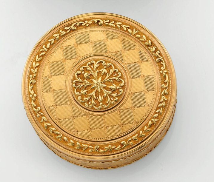 BOÎTE circulaire en or jaune ciselé et guilloché à motifs de rosace, guirlandes et damier