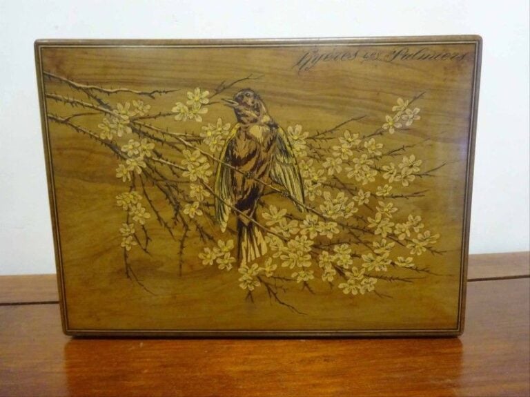 Boîte couverte de section rectangulaire en marquèterie de citrionnier ornée sur le dessus du couvercle d'un oiseau perché sur des branches fleuries une inscription en haut à droite: "Hyères les Palmiers