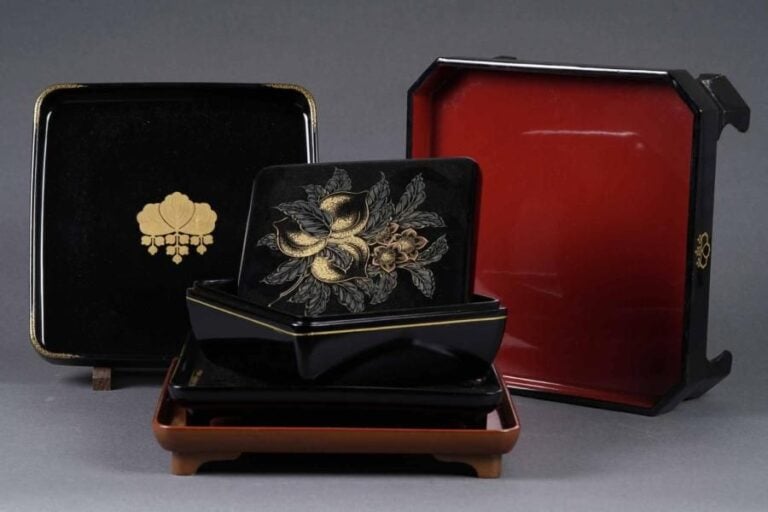 BOITE COUVERTE QUADRANGULAIRE A DECOR DE TROIS PECHES ET SON PRESENTOIR Japon, Epoque XXe siècle Dimensions (maximales, prenant en compte le présentoir): H: 10 cm - Côté: 22,5 cm Elle est offerte à la vente dans sa boîte en bois d'origine On y joint un plateau quadrangulaire à bords arrondis et son présentoir quadripode (un pied accidenté) octogonal, bois laqué, noir sur l'extérieur et rouge en son sein s'agissant du présentoir, noir avec décor à l'or d'une gentiane et d'une résille pointillé