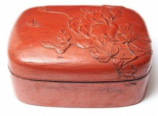 Boite de forme ovale décorée d'un motif gravé en laque rouge (tsuishu) figurant des pivoines et un papillo