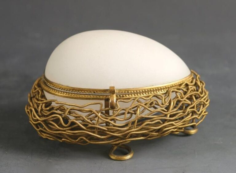 Boîte en forme d'oeuf en opaline pâte de riz satinée, présenté sur un nid en pomponne et fils doré