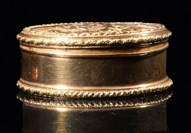 Boîte ovale en or uni et or amati; le couvercle à décor d'un personnage drapé, dans un char tiré par des colombes, sur une nué