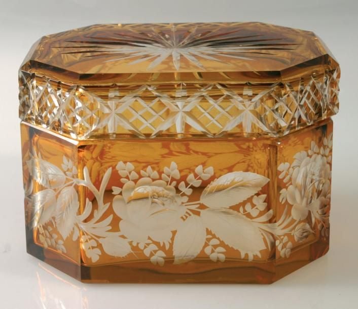 Boîte rectangulaire à coins coupés en verre cémenté ambre taille-gravé de motifs végétaux, le couvercle taillé à motifs géométriques (choc au bord interne