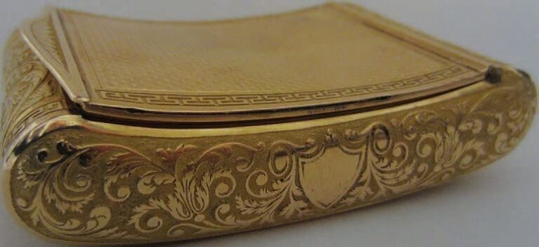 Boîte rectangulaire en or, le couvercle et le fond guillochés et à frises de grecques, les bordures à rinceaux feuillagés sur un fond amat
