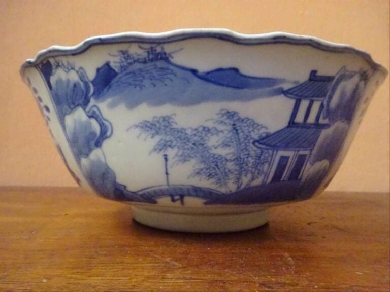 BOL A LEVRE FESTONNEE EN PORCELAINE BLEU BLANC A DECOR DE SYMBOLES AUSPICIEUX Chine, Fine de la Dynastie Qing, circa 1900 De forme carénée, à lèvre festonnée, reposant sur un pied annulair