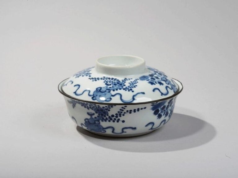 Bol couvert en porcelaine à décor en bleu sous couverte de vases fleuris et objets de lettré