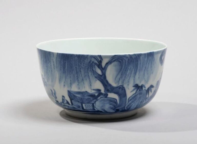 Bol en porcelaine décorée en bleu sous couverte d'un lettré dans une barque près d'une rive et poèm