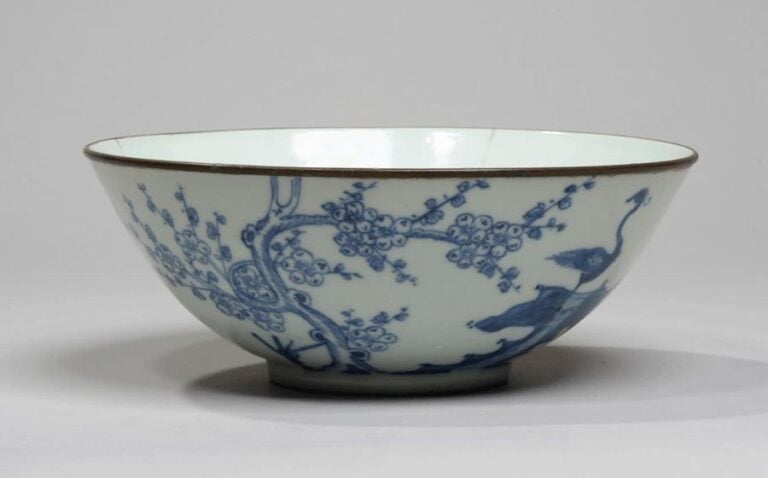 Bol évasé en porcelaine à décor en bleu sous couverte d'une grue sur un rocher près d'un prunier en fleu