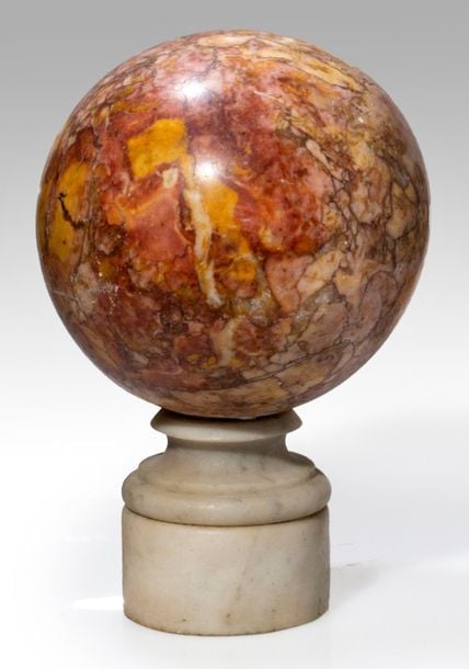 Boule de rampe en marbre jaspé rose, ocre et marron, sur un piédouche en marbre gris et socle en marbre blan