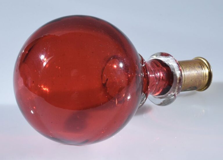 Boule de rampe en verre rouge; monture en laiton dor