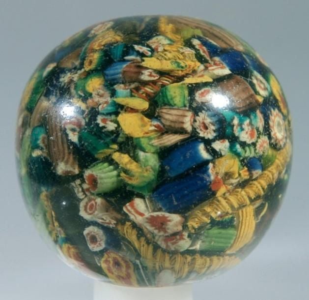 Boule décorative en verre orné en inclusion de cannes polychromes en pêle-mêle (rayures et égrenure d'usage