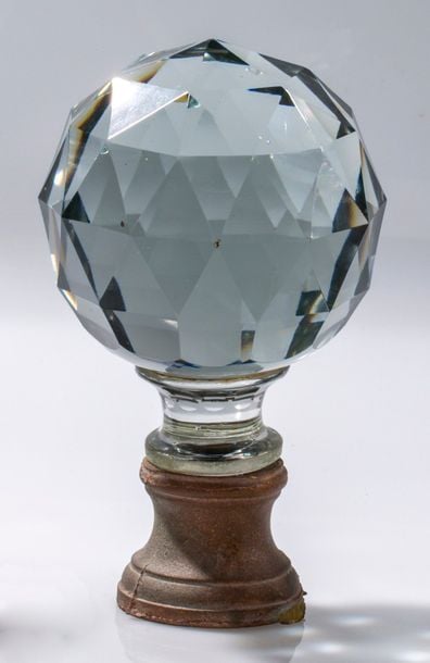 Boule en cristal massif taillé à facettes; monture en laiton dor