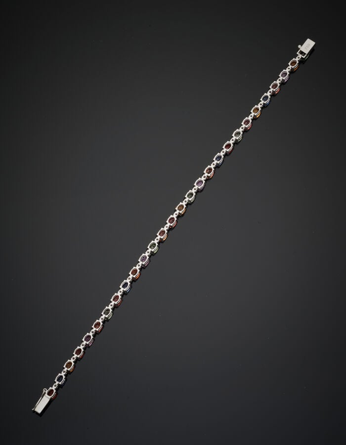BRACELET "arc-en-ciel" en or gris (750‰) serti d'un alignement de saphirs ovale…